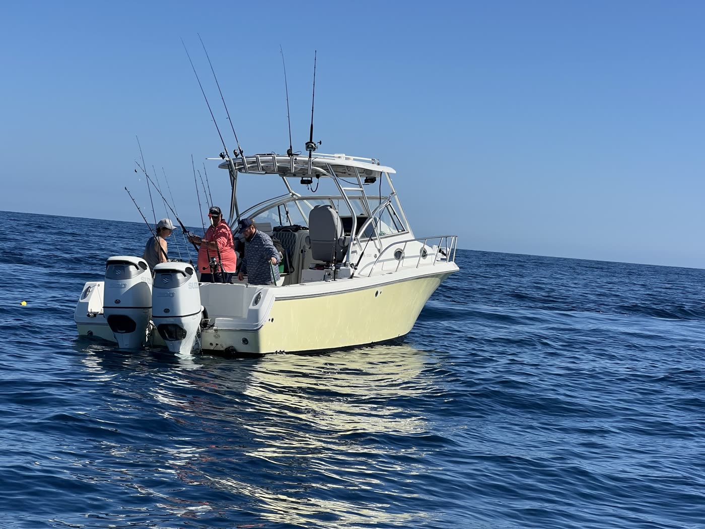 Off The Clock's walkaround express fisherman at anchor, twin Suzuki 300 outboards on the transom